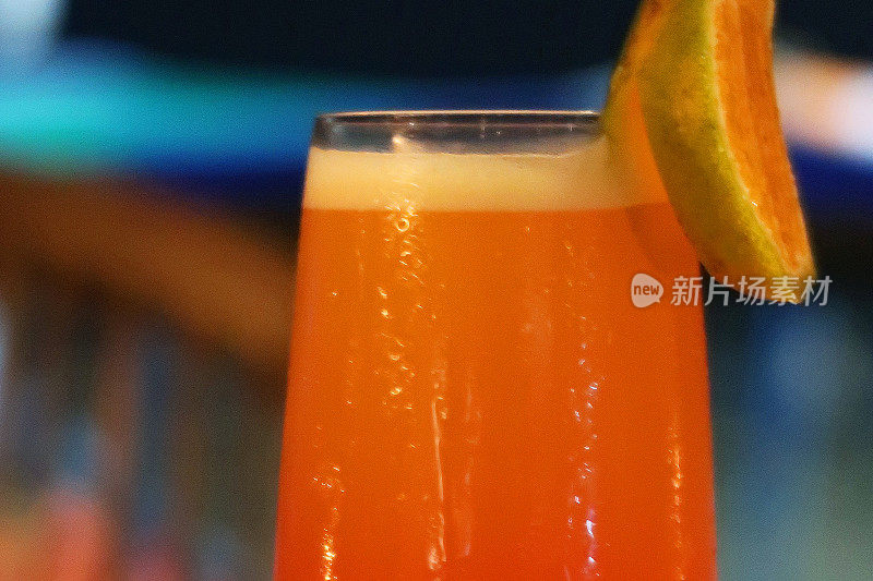 “沙滩上的性爱”鸡尾酒/橙汁鸡尾酒，印度海滩餐厅餐桌的特写，聚焦前景